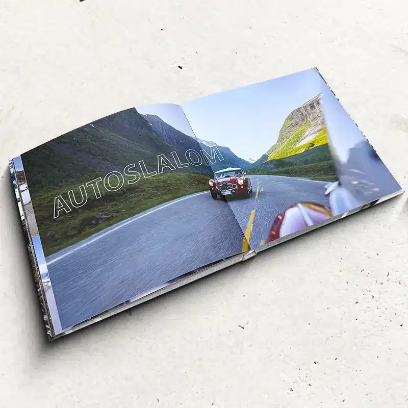 Open hardcover photo book with a printed interior spread and rigid cover